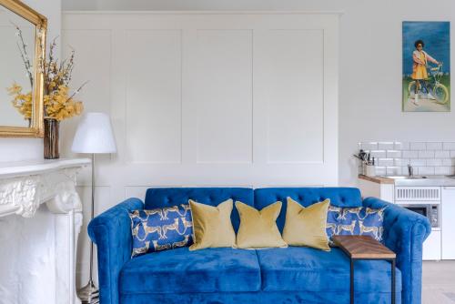 a blue couch with yellow pillows in a living room at 4 Berkeley Square I Your Apartment in Bristol