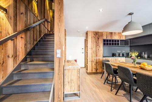 - une cuisine et une salle à manger avec des murs en bois et des escaliers dans l'établissement Chalet Herzog Argentière Chamonix - by EMERALD STAY, à Chamonix-Mont-Blanc
