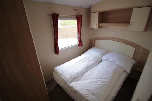 a bed in a small room with a window at Merlin's Camp in Znojmo