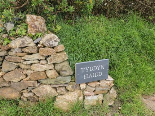 a stone wall with a sign on top of it at Tyddyn Haidd in Amlwch