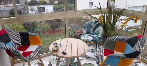 une chambre avec des chaises, une table et une fenêtre dans l'établissement Aux portes de locronan, à Quéménéven