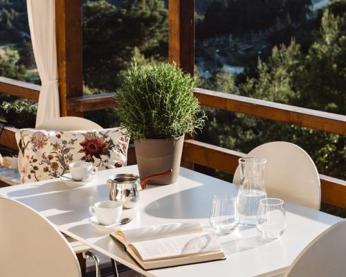 a white table with a plant on a balcony at Nature House with a wooden porch - Pasika, house Luca in Pučišća