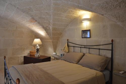 a bedroom with a bed in a stone wall at Corte Soleto 22 in Martano
