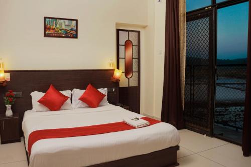 a bedroom with a large bed with red pillows at Paddyfield Inn in Mananthavady