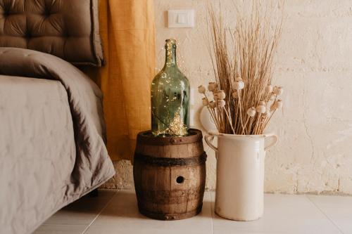 a bottle on top of a barrel next to a vase at Le Dodici Lune in Matera