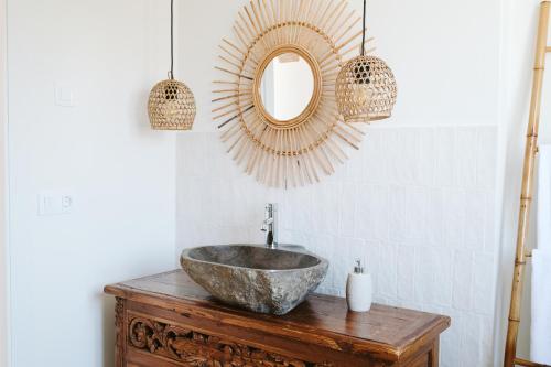 a bathroom with a stone sink and a mirror at Dreamsea Surf House Fuerteventura in Corralejo