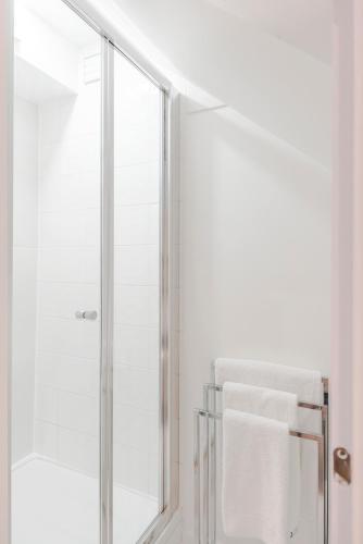 a bathroom with a glass shower with a white towel at 4 Berkeley Square I Your Apartment in Bristol
