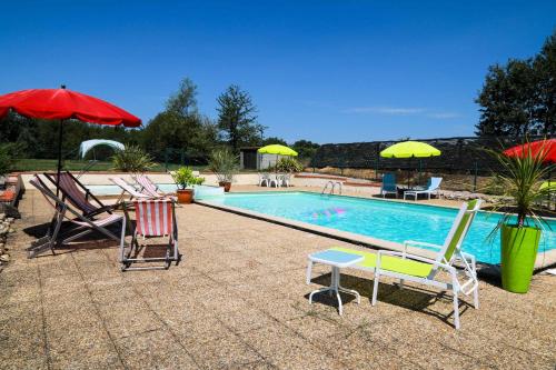- une piscine avec des chaises, des parasols, une table et des chaises dans l'établissement L'Atelier @ Le Prielle, à Madiran