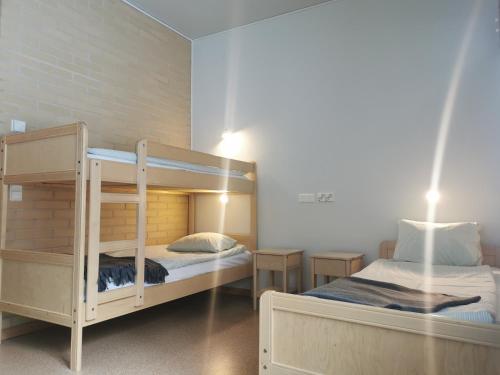 a bedroom with two bunk beds and two tables at Nuoriso- ja luontomatkailukeskus Oivanki in Oivanki