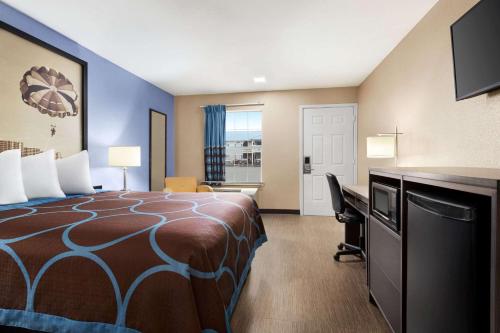 a hotel room with a bed and a desk at Super 8 by Wyndham Foley in Foley