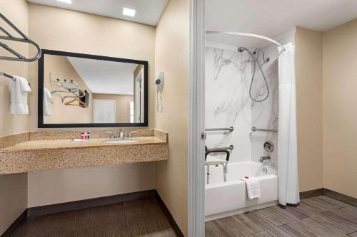 a bathroom with a tub and a sink and a shower at Super 8 by Wyndham Foley in Foley