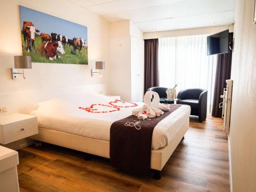 een hotelkamer met een bed en een schilderij van koeien bij Best Western Hotel Slenaken in Slenaken