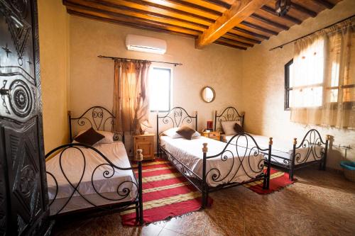 a bedroom with two beds and a window at Original Surf Morocco in Tamraght Ouzdar