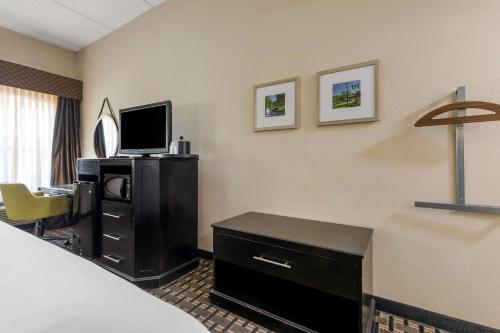 a hotel room with a bed and a desk with a television at Comfort Inn Sherman in Sherman