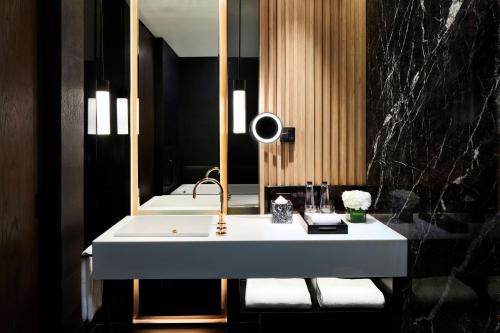 een badkamer met een wastafel en een spiegel bij Park Hyatt Jakarta in Jakarta