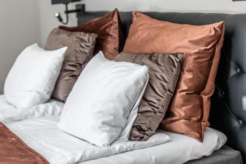 a bunch of pillows sitting on a couch at Cameo Boutique Hotell in Ystad