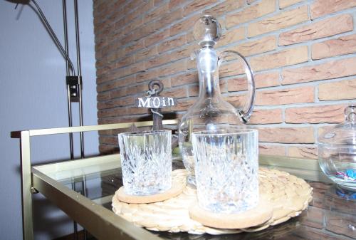 einen Glastisch mit zwei Gläsern darüber in der Unterkunft Ostfreesenhuus Vier Pfoten in Marienhafe