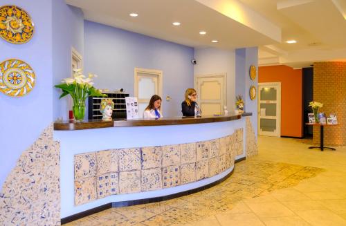 two women sitting at a bar in a lobby at Hotel Baglio Di Scopello in Scopello