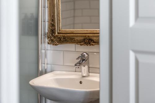 a bathroom with a sink and a mirror at Cameo Boutique Hotell in Ystad