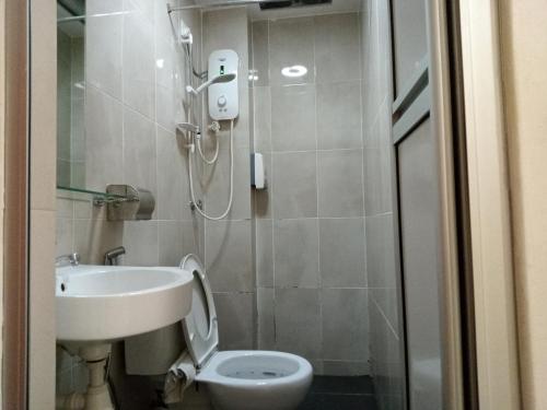 a bathroom with a shower and a toilet and a sink at AVENUE BANGI HOTEL in Kajang