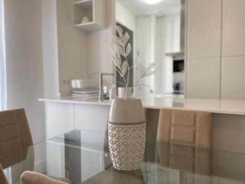 a kitchen with a glass table with a vase on it at Apartamento Centro Alhóndiga Suite in Granada