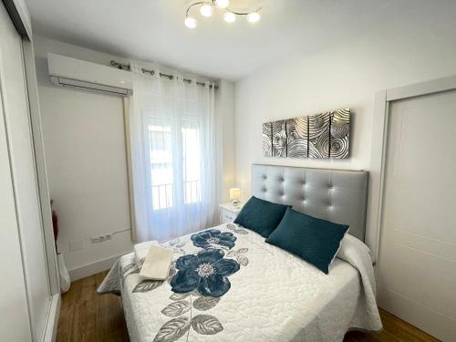 een slaapkamer met een groot bed met blauwe kussens bij Apartamento Centro Alhóndiga Suite in Granada