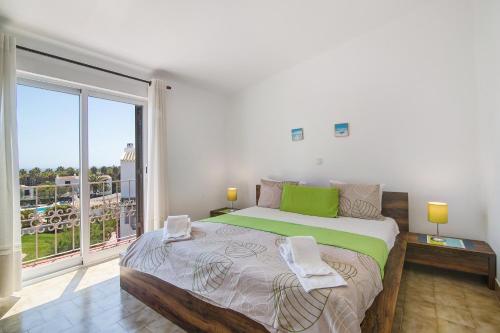a bedroom with a large bed and a large window at São Rafael Praia in Albufeira