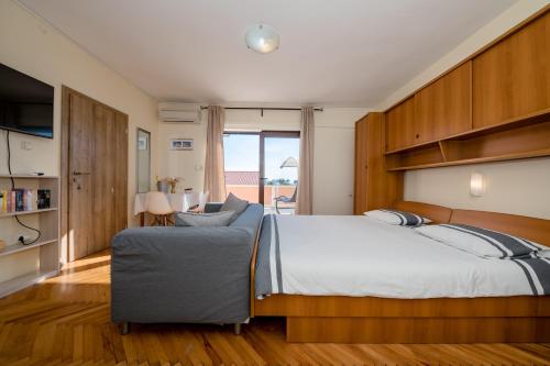 a bedroom with a large bed and a couch at Apartments Tartuga in Rab