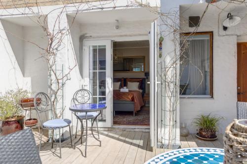 a patio with a table and chairs and a bedroom at Cameo Boutique Hotell in Ystad
