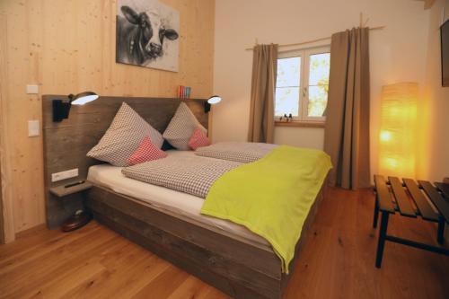 a bedroom with a bed with a green blanket on it at Ferienwohnung Birkennest in Bad Heilbrunn