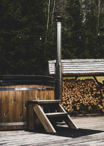a pile of fire wood sitting next to a wooden building at Osada Poli Koniaków - Panoramiczny Domek nr 3 z Prywatną Balią i Hydromasażem in Koniaków