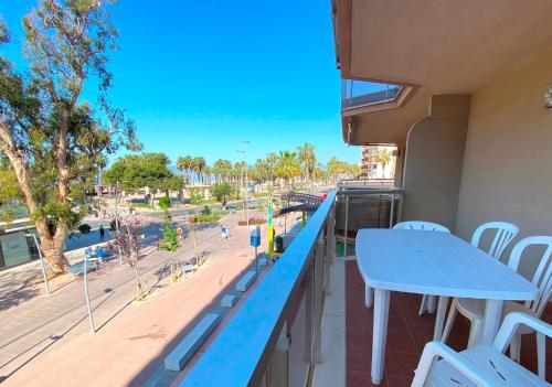 a balcony with a blue table and chairs and a view of the beach at El Pinar Fuente Luminosa in Salou