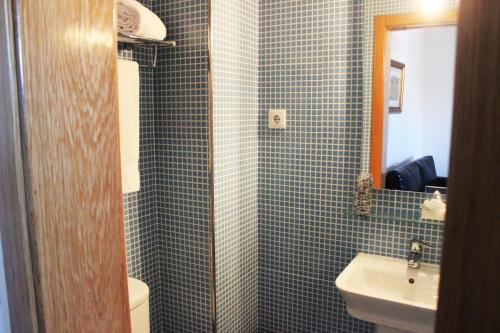 a blue tiled bathroom with a sink and a toilet at Curral de l Tiu Pino in Sendim
