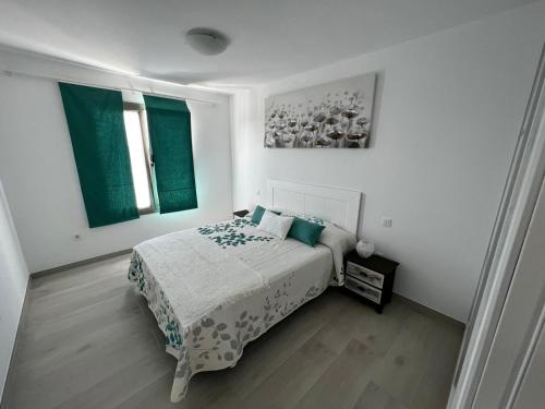 a white bedroom with a bed and two windows at Arrecife exclusive beach house in Arrecife