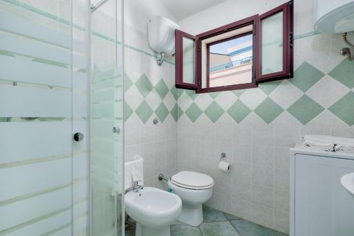 W łazience znajduje się toaleta i przeszklony prysznic. w obiekcie APPARTAMENTO DEL CAPITANO w mieście Cala Gonone