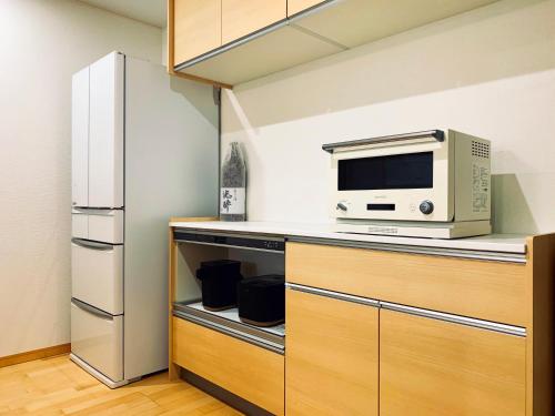 uma cozinha com um micro-ondas e um frigorífico em K.House em Tóquio