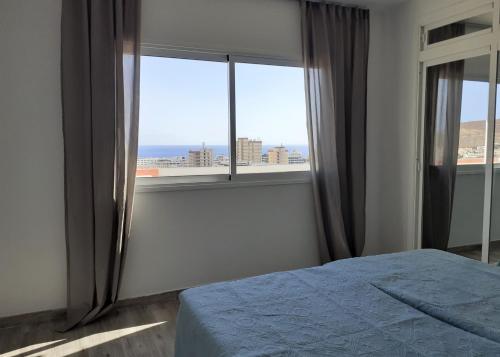 um quarto com uma cama e vista para o oceano em KC home abroad panoramic sea view em Playa de las Americas