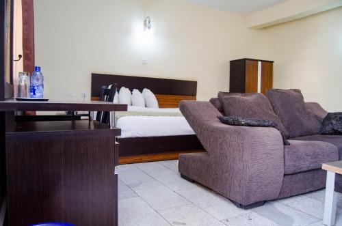 a living room with a couch and a bed at Residency Hotel Area11 Garki Abuja in Abuja