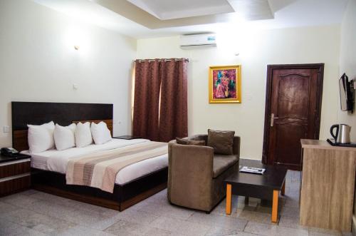 a hotel room with a bed and a chair at Residency Hotel Area11 Garki Abuja in Abuja