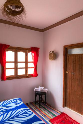 a bedroom with a bed and a window and a table at Amazigh Family Riad in Imlil