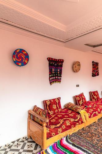 a bedroom with a couch and pillows on the wall at Amazigh Family Riad in Imlil