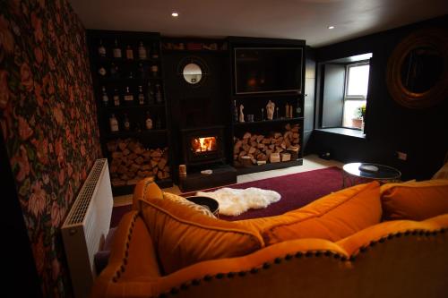 sala de estar con sofá y chimenea en Charming 2-Bed House in West Cork Cupid's Cottage en Kealkill