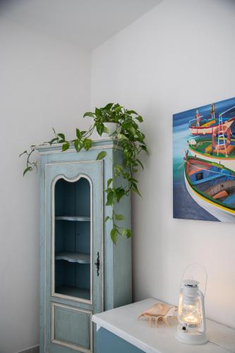 a blue cabinet with a plant on top of a table at Cà Miciàt in Cervia