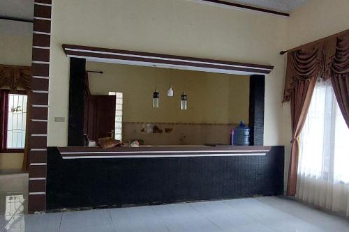espejo grande en el baño con bañera en OYO HOMES 91255 Desa Wisata Embung Purworejo Syariah, 