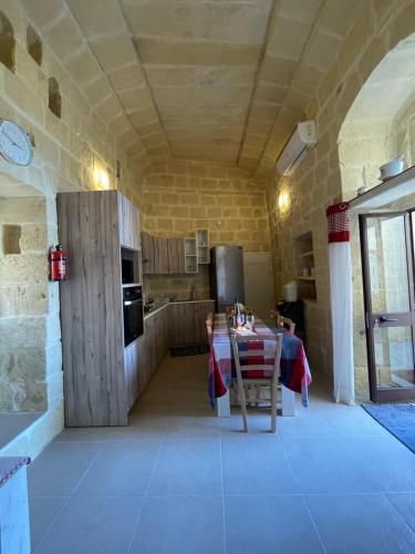 een keuken met een tafel en een koelkast in een kamer bij Taz-Zubi Farmhouse in San Katald