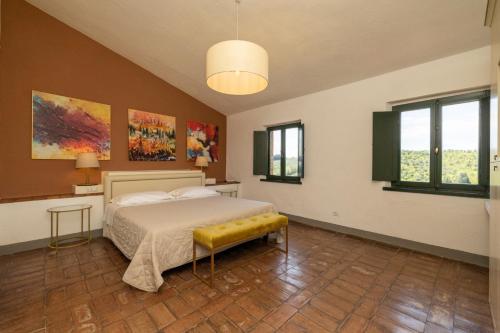 a bedroom with a bed and two windows at Hotel Pescille in San Gimignano