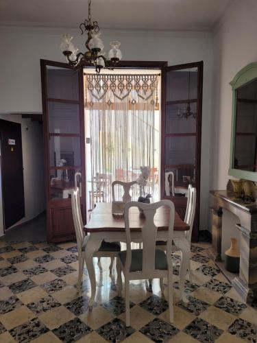 a dining room with a table and chairs and a window at Casal de Petra - Rooms & Pool by My Rooms Hotels TI in Petra