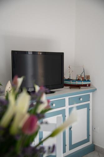 a flat screen tv sitting on top of a blue cabinet at Cà Miciàt in Cervia