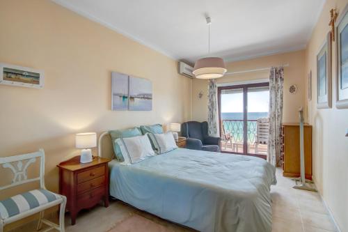 アルマカオ・デ・ペラにあるApartamento beira marのベッドルーム(ベッド1台付)、バルコニーが備わります。