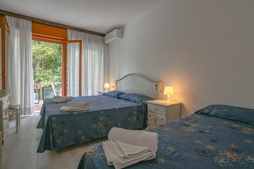 a bedroom with two beds and a window at Hotel Adriaco in Grado